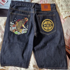 Evisu jorts - Storlek 28 på midjan, Evisu jorts, oanvända med snygg design på fickorna, knä längd 