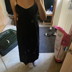 Svart långklänning  - Klänningen är aldrig använd, går ner till fotknölarna på mig ungefär (är 165 cm lång) och är storlek xs