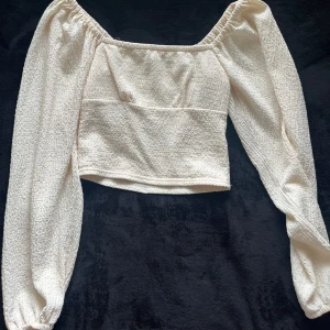 Långärmad topp från Bik Bok - Super söt topp från Bik Bok i storlek XS, säljer den då den inte passar mig längre. Den är gräddfärgad och i nyskick 