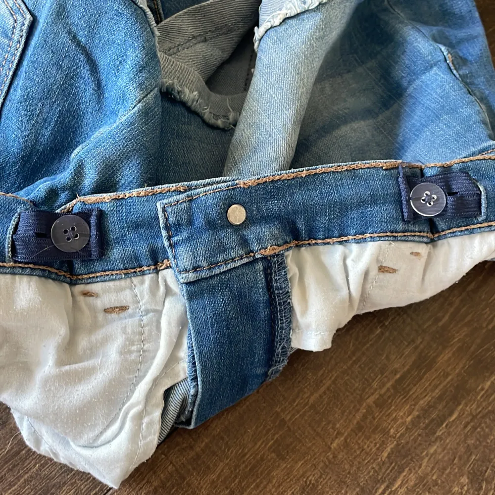 Blåa jeansshorts som har mellanhög midja, med justerbar resår runt midjan. Välanvända men i väldigt sparsamt och gott skick. . Shorts.