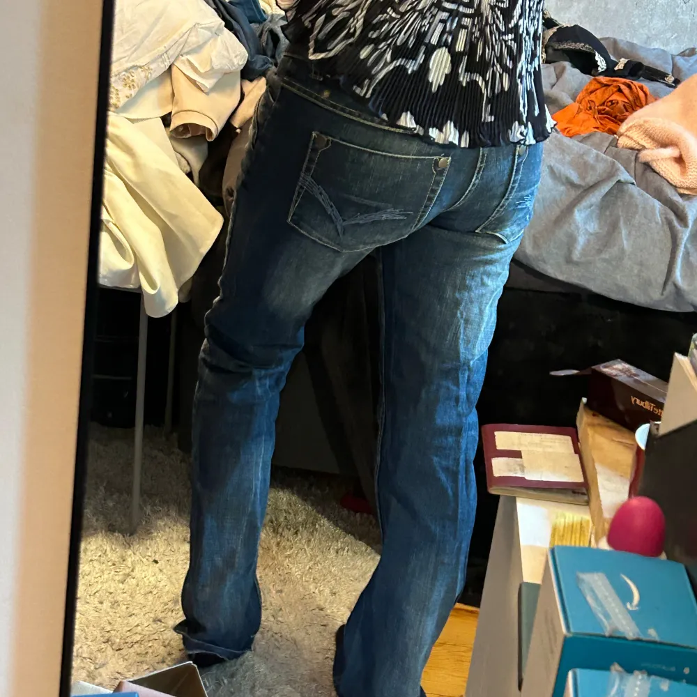 Säljer ett par snygga blå jeans med låg midja. De är i bra skick och har en klassisk femficksdesign med knappar och dragkedja framtill. Perfekta för vardagsbruk och kan matchas med nästan vad som helst. Passar bra till både sneakers och klackar. . Jeans & Byxor.