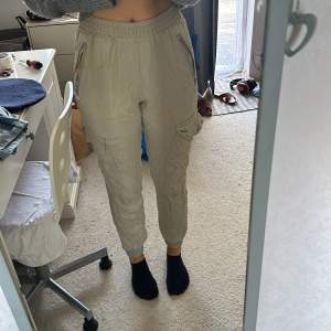 Säljer ett par snygga beige cargopants från BikBok i storlek XS. Byxorna har en elastisk midja och flera praktiska fickor med dragkedjor och knappar. Perfekta för en avslappnad och trendig look! har även ett par svarta man kan få på köpet om man köper dessa 