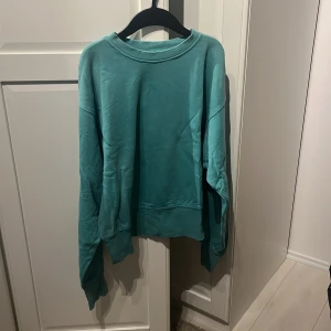 Turkos sweatshirt  - Turkos sweatshirt med bokstaven B i färgen gul. Storlek M från Bik Bok