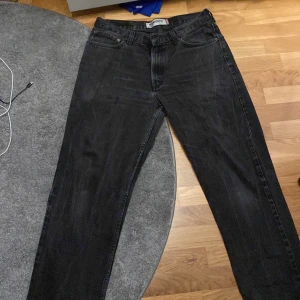 Svarta Levis 550 jeans - Säljer ett par svarta Levis 550 jeans i storlek W34 L32. De är i relaxed fit och har en klassisk design med fem fickor och dragkedja. Perfekta för en avslappnad stil!