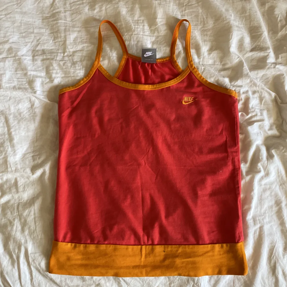 Vintage corall rött Nike linne med orange detaljer, köpt här på Plick. Säljer då det tyvärr ej kommer till användning. Färgen syns bäst på sista bilden💛. Toppar.