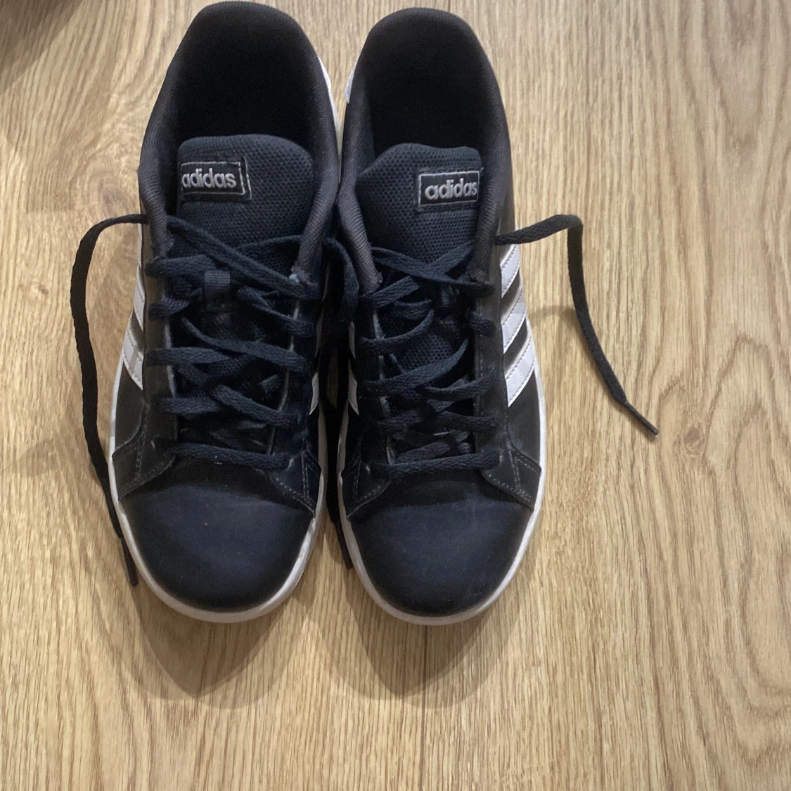 Svarta Adidas sneakers med vita ränder