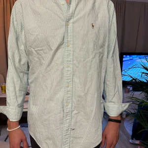 Ralph Lauren skjorta - Säljer min otroligt fina randiga Ralph Lauren Oxford skjorta i nyskick. Perfekt till sommaren. Hör av dig vid frågor!