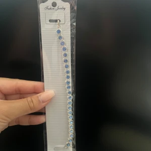 Silverfärgat armband med blå stenar - Säljer ett elegant silverfärgat armband med blå stenar. Armbandet är nytt och kommer i originalförpackning. Perfekt för fest eller andra speciella tillfällen. Köp direkt eller ge prisförslag 💙