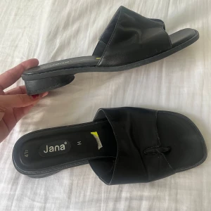 Svarta sandaler från Jana - Säljer ett par svarta sandaler från Jana i storlek 4 1/2. De är i syntetmaterial och har en enkel och stilren design. Perfekta för sommaren och passar till både vardag och fest. De är i bra skick och väldigt bekväma att gå i.