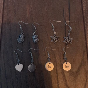 Örhängen - Säljer fyra par örhängen för 30kr/st och alla för 100kr🤍Ett par med ugglor, ett par med stjärnor, ett par med hjärtan och ett par med runda plattor med texten 'love'.🤍 Alla örhängen är i silverfärg och har krokfästen. Har gjort själv och är aldrig använda. 🤍 Köparen står för frakt🤍
