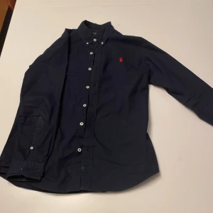 Polo Ralph Lauren skjorta  - Snygg Raffe skjorta i strl S, bra skick Skjortan är snygg mörkblå. Hör av dig för fler frågor! 