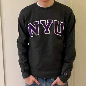 En grå NYU sweatshirt från Champion. Tröjans kvalite är bra och storleken är small, S.