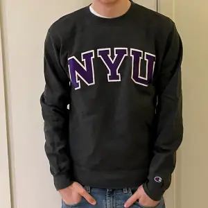 En grå NYU sweatshirt från Champion. Tröjans kvalite är bra och storleken är small, S.