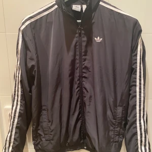 Jacka - Jacka Adidas, strl 28. Oversized. Inköpt på Adidasbutiken på Sveavägen 230423, kvitto finns. Tyvärr har sonen växt ur den redan (nu 14 år) Nypris 1099 kr, säljes för halva priset 550kr. Hel och ren. 