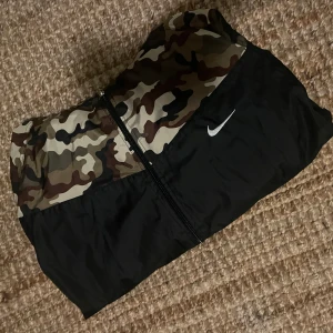 Nike vindjacka  - Nike vindjacka med militär vid bröstet, storlek s men skulle passa m med då den är rätt rymlig i och med materialet kom med prisförslag 