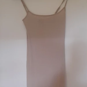 Gina tricot klänning - En klänning från gina tricot. Den är lång och beach , ganska så tajt och passar in i ens kropp. Använd bara 2 gånger . 