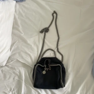 Stella McCartney falabella mini - En mörkblå Stella mccartneyväska i den minsta modellen. Den ska säljas då den inte kommer till användning lika mycket längre. Den är köpt för tre år sedan och nypriset var 8000 kr. Priset kan diskuteras💕