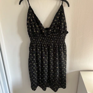 Svart klänning  - En Svart kort klänning köpt från Shein med små blommor som mönster. Det är storlek L men jag skulle säga att den passar för S och M.