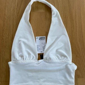 Vit halterneck topp HM - Aldrig använd halterneck topp från HM med prislappen kvar i storlek XS. Slutsåld på HM. 