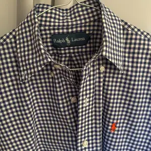 Rutig skjorta från Ralph Lauren Mycket fint skick, använd enbart enstaka gång! Skjortan tvättad och pressad på kemtvätt inför försäljningen  Storlek: Small (41cm bred och 72cm lång) 100% bomull