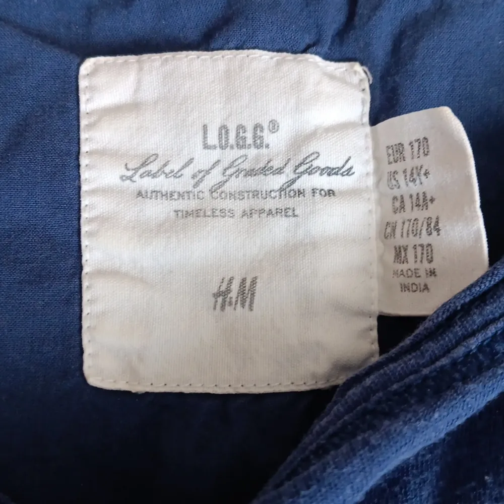 Mörkblå tröja från H&M. Baksidan, ärmarna och fickan är av mörkblå spets i ett blommigt mönster. Blusar.
