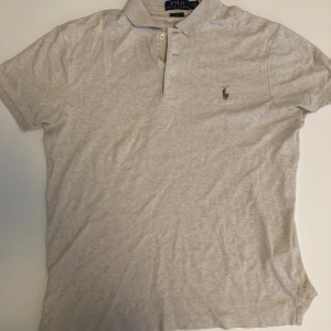 Ralph Lauren T-shirt - Fin och sparsamt använd Ralph lauren tröja som är i perfekt skick med inget slitage. I beige/vit färg.