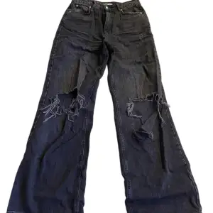 svarta highwaist vida jeans med stora hål! liten fläck bak på låret. strl. 40 från gina tricot! använda, relativt bra skick