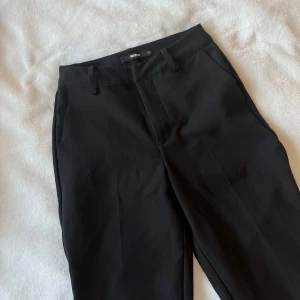 Svarta kostymbyxor från Bikbok - Den populära och klassiska kostymbyxan från BikBok. De är i svart, midwaist, med dragkedja och spänne i midjan. Kostymbyxan är i straight modell. Jättefint skick och oskadade. Storlek 34. 💗