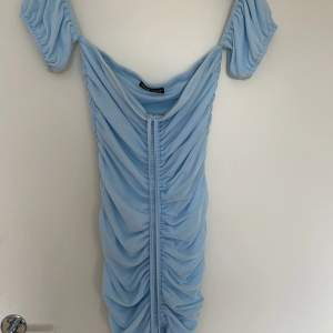 En babyblå off shoulder, medellång klänning lite åt det korta hållet. Aldrig använts i storlek S