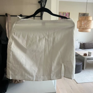 Vit kjol - Kort vit kjol med en liten slits. Oanvänd 
