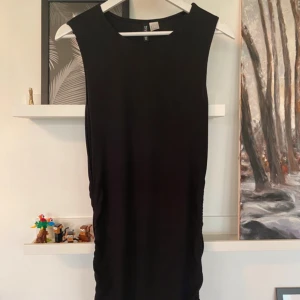 Klänning - Med ”drag” längs sidorna  Fint skick 