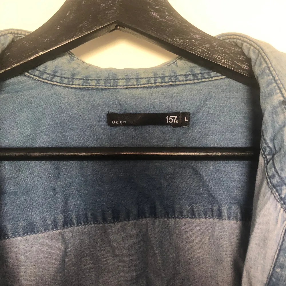 Säljer en jeans skjorta, den är i bra skick förutom att den har en liten fläck på ena armen som visas på sista bilden🫶 . Skjortor.