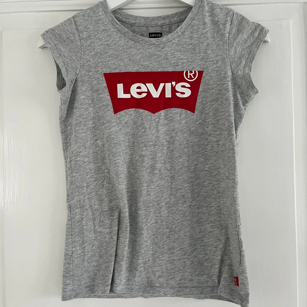 Grå figursydd t-shirt med Levistryck. Fint skick storlek 140. . T-shirts.