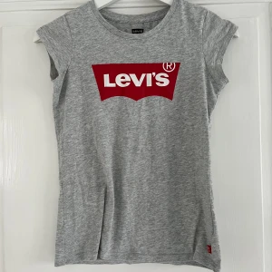 T shirt Levis - Grå figursydd t-shirt med Levistryck. Fint skick storlek 140. 