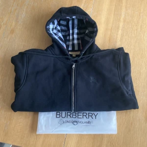 Svart Burberry Zip Up. - Säljer min Svarta Burberry Zip Up då jag inte har användning av den mer pågrund av att den är för liten. Storlek: XL/ L då denna passar lika bra L  Inga defekter på tröjan Kontakta mig vid intresse eller frågor!  (Möjligt att pruta vid trevlig affär)