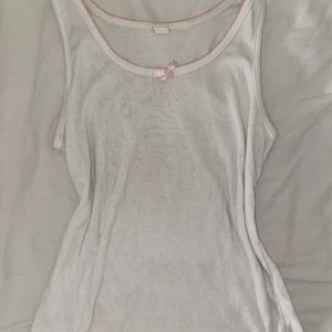 Nattlinne - Så gulligt nattlinne med rosa rosett. Lite smånopprig, annars i bra skick! 💕