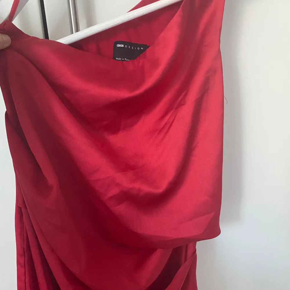 Säljer min röda balklänning som endast använts en gång. Klänningen är från asos och i storlek 32. Den är one shoulder och snedskuren längst ner😊. Klänningar.