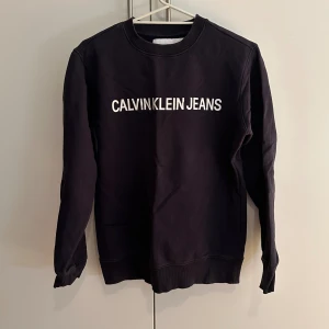 Calvin Klein crew neck - Calvin Klein crew neck i marin blå som är knappt använd och befinner sig i ett väldigt fint skick. Storleken på tröjan är Xs men den passar även S då den är lite stor i Storleken.