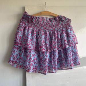 Superfin somrig kjol i blommigt tyg, blå/rosa/lila, från Vero Moda! Storlek L men Passar S-L. Först till kvarn!