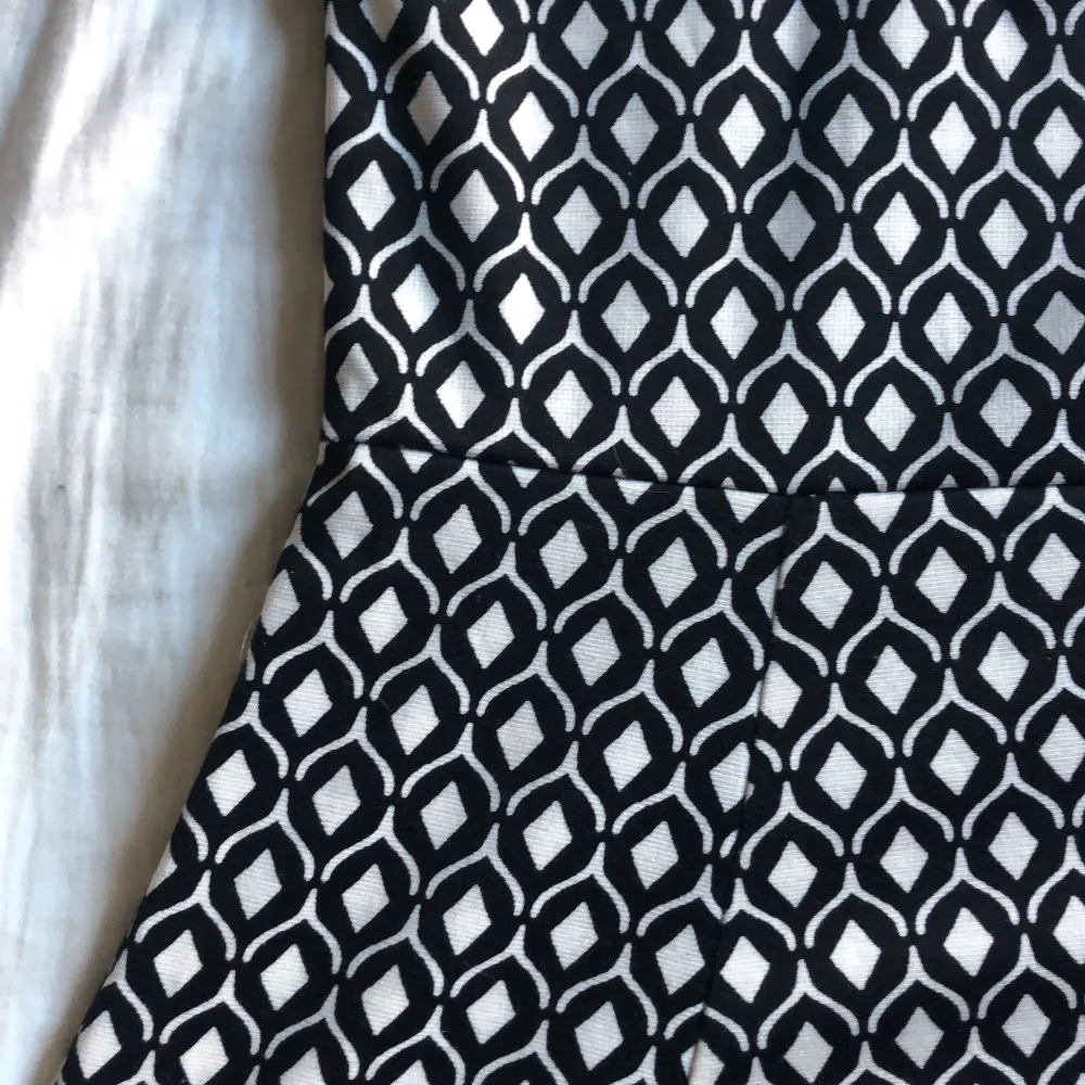 En vit och svart klänning i ett coolt mönster och med snygg öppen rygg-detalj! Härlig om du gillar att ta ut svängarna med mönster och roliga detaljer . Klänningar.
