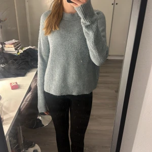 Stickad tröja  - En blå/grön stickad tröja som är bra skick och aldrig använd