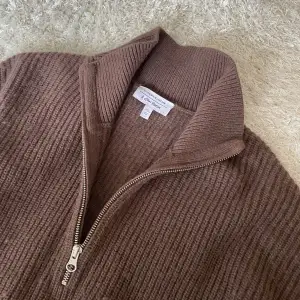 Brun stickad tröja från & Other Stories Brungrovstickad, ribbad sweatshirt i merinoullblandning med kort dragkedja💘varan är är lite nopprig. Nypris 1395kr🫶🏻