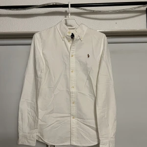 Vit Ralph Lauren skjorta - Vit Ralph Lauren skjorta. Inte använd mycket alls pga den är lite för liten på mig. Storlek S/M. Skriv i DM om du undrar något!