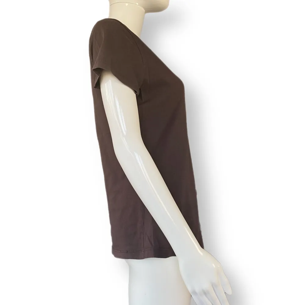 En mörkbrun t-shirt med hibiskusprint, i fint skick. Storlek M, från Sun T’s. 100% bomull. MÅTT: Axel till axel 39cm, ärmlängd 15.5cm, armhåla till armhåla 48cm & längd 62cm . T-shirts.