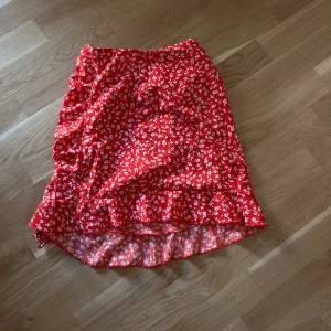 Röd kjol med vita blommor - En helt oanvänd kjol