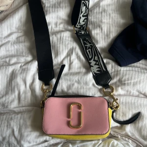 Handväska Marc Jacobs - En färgglad liten handväska! Använd fåtal gånger, säljer eftersom den inte kommer till användning😢. Inga märkvärdiga defekter förutom en liten sminkfläck på insidan. Köpt från Jolina i Borås för 3800kr, därmed helt äkta👏🏻❤️Mycket bra/ bra skick!!