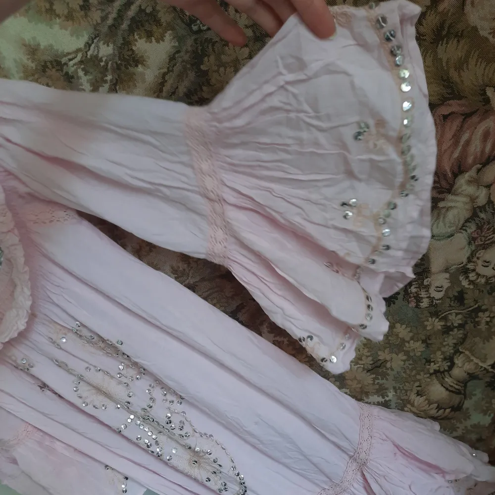 Rosa klänning med mycket fina detaljer, paljetter, spets, utsvängda ärmar och utsvängt nedtill. One size och super stretchig så passar de flesta 💖✨️. Klänningar.