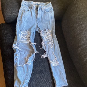 Blå slitna jeans - Jeans med stora hål vid knäna. Finns knappt täcken på användning så är som nya. 