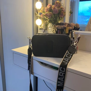 Marc Jacobs väska  - Hej💓 Säljer en marc Jacobs väska i svart med silver detaljer. Bra stick och knabbt använd. Pris kan diskuteras.
