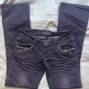 Sjukt coola lågmidjade jeans med häftig mörklila färg och coola detaljer i mycket gott skick! 